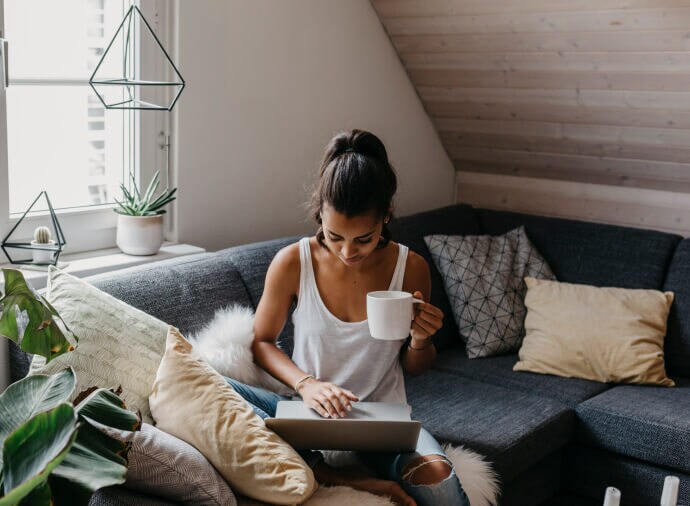 Muž, který při odpočinku na gauči používá notebook