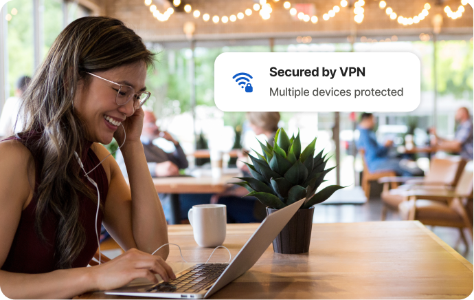 Žena v kavárně se směje na obrazovku notebooku